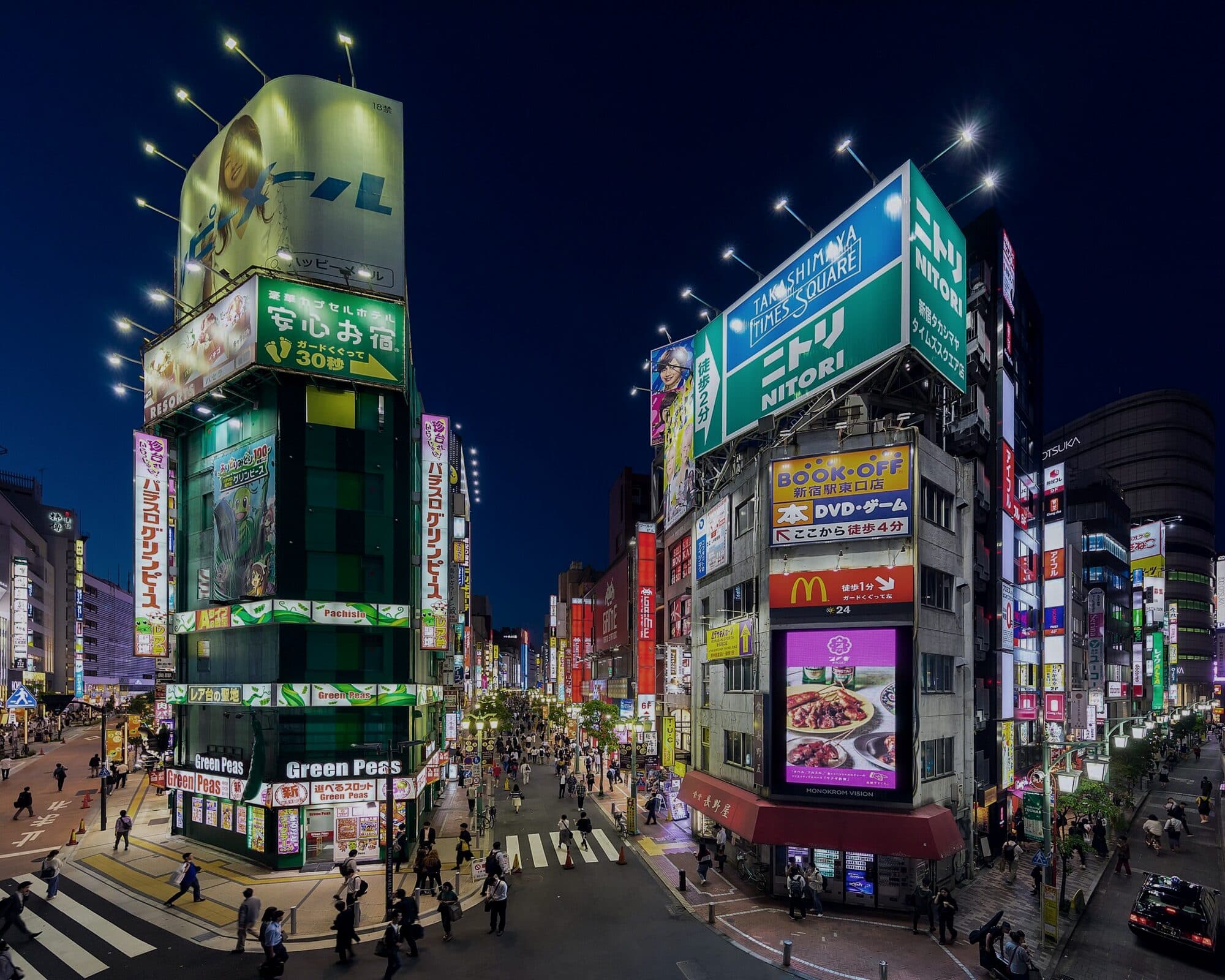 Advertising screens over a city street at blue hour